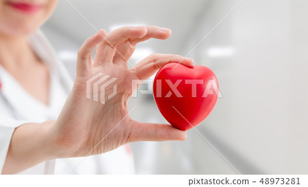 Doctor holding a red heart at hospital office. Doctor holding a red heart at hospital office. 48973281