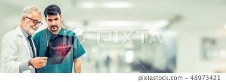 Doctors at hospital working with another doctor. 48973421