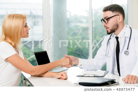 Male Doctor and Female Patient in Hospital Office 48973477
