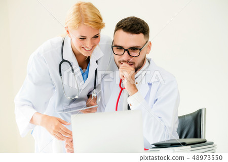Doctor at hospital works on computer with partner. Doctor at hospital works on computer with partner. 48973550
