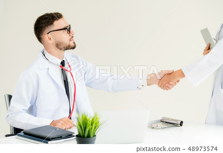 Doctor at hospital shakes hand with another doctor 48973574