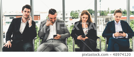 Businesswomen and businessmen using mobile phone. Businesswomen and businessmen using mobile phone. 48974120