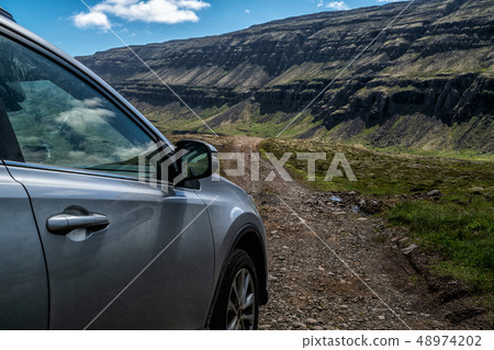SUV vehicle car running on gravel road. 48974202