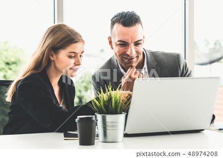 Businessman and businesswoman working in office. 48974208