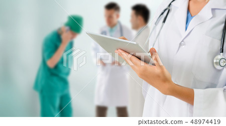 Doctor working in hospital with other doctors. Doctor working in hospital with other doctors. 48974419