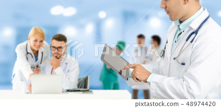 Doctor working in hospital with other doctors. 48974420