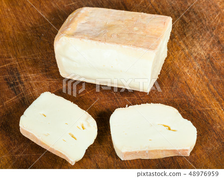 sliced local italian Taleggio cheese on board 48976959
