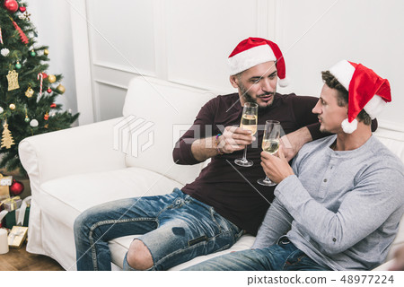 Gay male couple celebrating Chritsmas at home Gay male couple celebrating Chritsmas at home 48977224