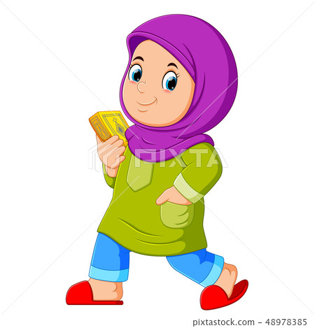 Moslem girl walking and carrying holy Quran 48978385