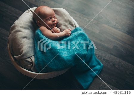 newborn baby wrapped in a blanket sleeping in a newborn baby wrapped in a blanket sleeping in a 48981316