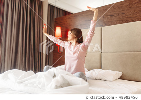 Young woman wake up in the morning, stretching Young woman wake up in the morning, stretching 48982456