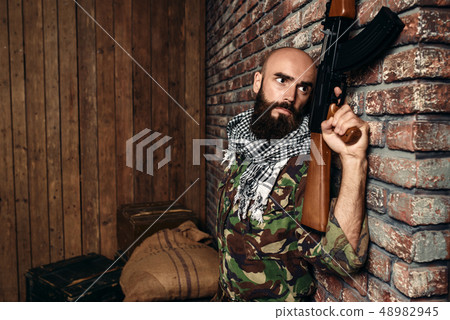Terrorist with rifle hiding behind a wall Terrorist with rifle hiding behind a wall 48982945