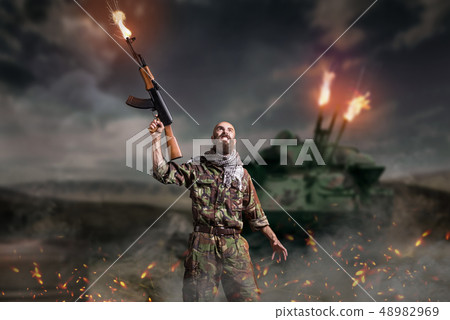 Terrorist with rifle stands in explosion and fire Terrorist with rifle stands in explosion and fire 48982969