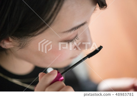 一位年輕日本婦女繪畫染睫毛油 一位年輕日本婦女繪畫染睫毛油 48983781