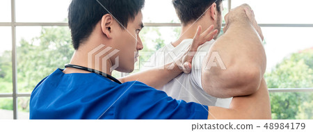 Asian physical therapist stretching athlete male Asian physical therapist stretching athlete male 48984179