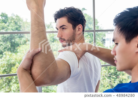 Physical therapist giving masssage and stretching Physical therapist giving masssage and stretching 48984280
