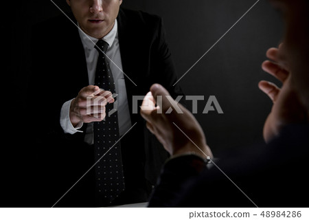 Detective pointing hand to criminal man in dark Detective pointing hand to criminal man in dark 48984286