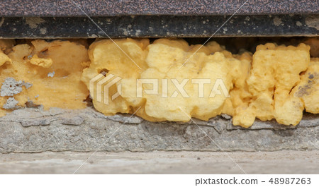 Construction foam in the wall slit as a background Construction foam in the wall slit as a background 48987263