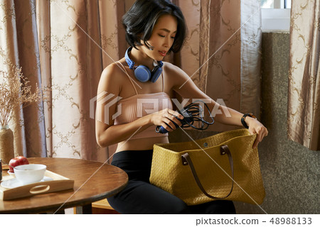 Young woman packing bag Young woman packing bag 48988133