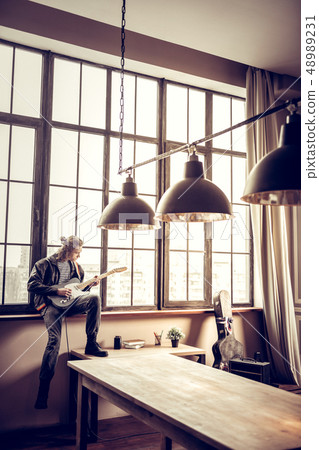 Rock musician sitting near window and composing new song 48989231