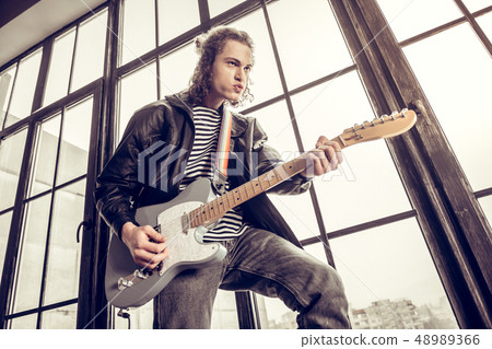 Rock musician wearing jacket feeling emotional playing rock 48989366