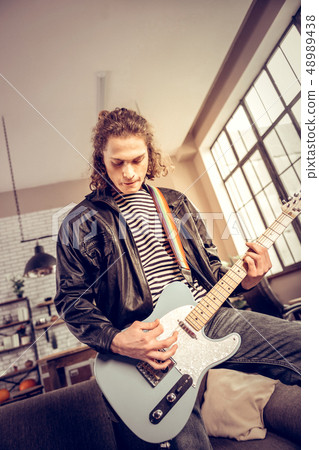 Curly dark-haired rock music player composing new song Curly dark-haired rock music player composing new song 48989438