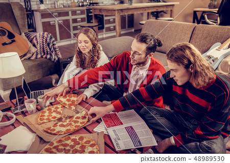Participants of music band eating pizza after composing music 48989530