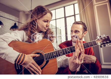 Bearded dark-haired man smiling while listening to his student 48989638