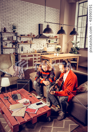 Two young inspired musicians sitting on sofa and composing music 48990591