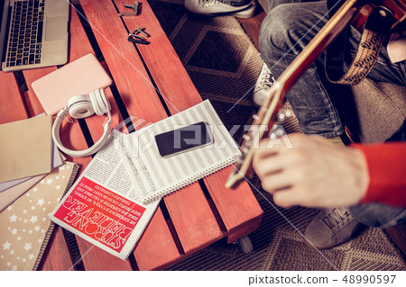 Musicians sitting neat the table with music note sheet and phone 48990597