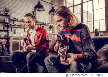 Musician with bob cut joining his friend playing the guitar 48990726