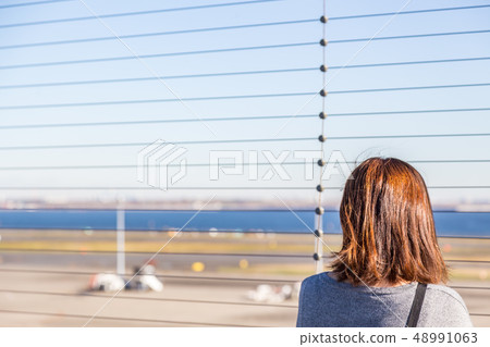 Woman staring at the plane Woman staring at the plane 48991063