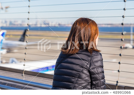 Woman staring at the plane 48991066