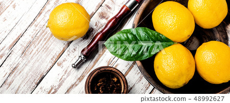 Smoking hookah with lemon flavor Smoking hookah with lemon flavor 48992627