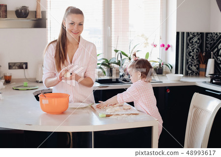 Little lovely kid helping parent with dough at Little lovely kid helping parent with dough at 48993617