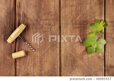 Overhead photo of vine leaf with corkscrew, cork, and copyspace Overhead photo of vine leaf with corkscrew, cork, and copyspace 48995457