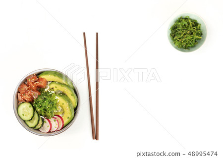 Hawaiian tuna poke salad on white, with wakame seaweed salad, chopsticks, and copy space Hawaiian tuna poke salad on white, with wakame seaweed salad, chopsticks, and copy space 48995474