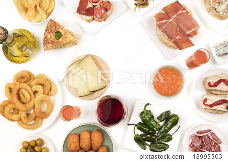 An overhead photo of Spanish tapas, forming frame on white with copy space 48995503