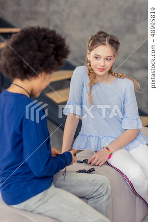 Charming longhaired blonde teenager looking at her friend 48995819