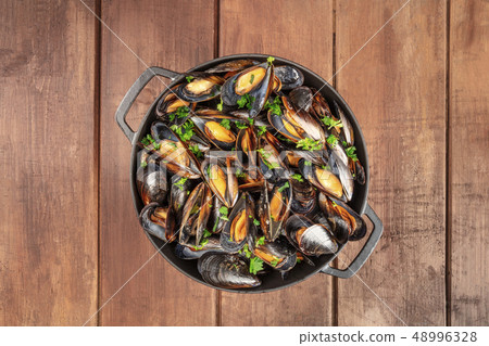 Skillet of marinara mussels on rustic background, overhead shot with copy space Skillet of marinara mussels on rustic background, overhead shot with copy space 48996328