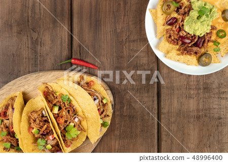 Mexican food with copy space, overhead photo of hot spicy tacos and nachos 48996400