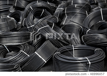 Spiral black plastic pipes, stored in the open Spiral black plastic pipes, stored in the open 48996857