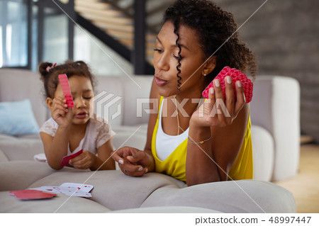 Pleased curly-haired female person leaning on sofa 48997447