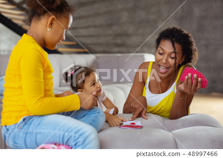 Happy young brunette woman pointing at card Happy young brunette woman pointing at card 48997466