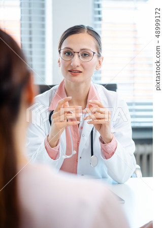 Young female doctor seeing woman patient Young female doctor seeing woman patient 48999172
