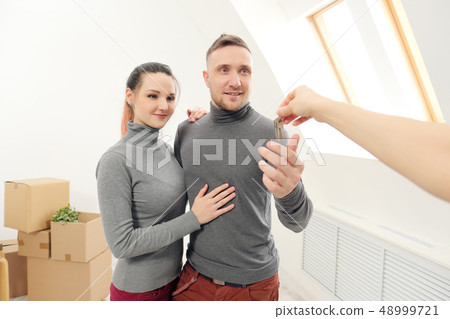 The seller gives customers the keys to the new apartment. The seller gives customers the keys to the new apartment. 48999721