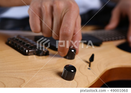 Male arms playing classic shape electric guitar 49001068