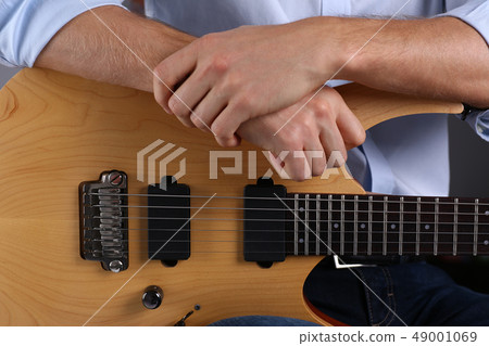 Male arms playing classic shape electric guitar 49001069