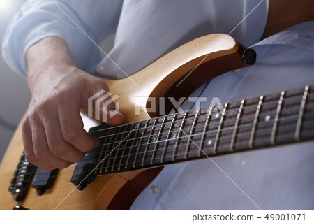 Male arms playing classic shape electric guitar 49001071