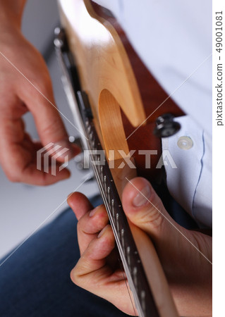 Male arms playing classic shape electric guitar 49001081